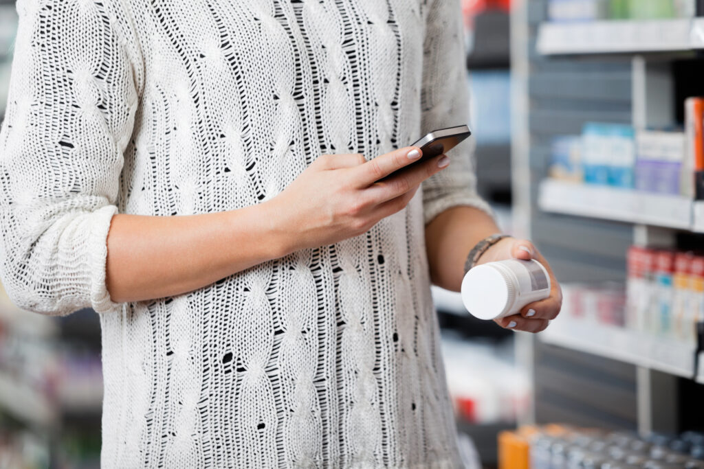 Consumer using their phone to scan a NFC tag on a supplement bottle in order to learn more about the product